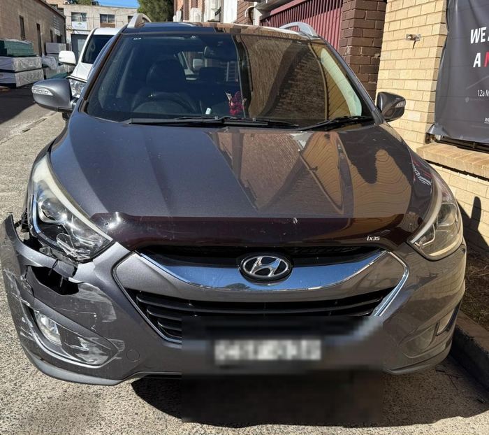 Hyundai ix35 with damaged front bumper and headlight before repair