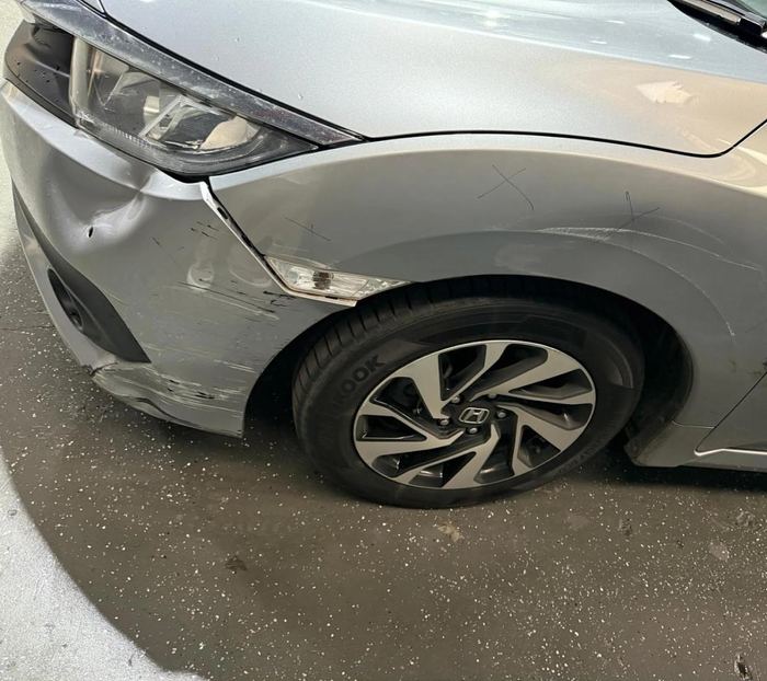 Honda Civic with dented and scraped front fender before repair