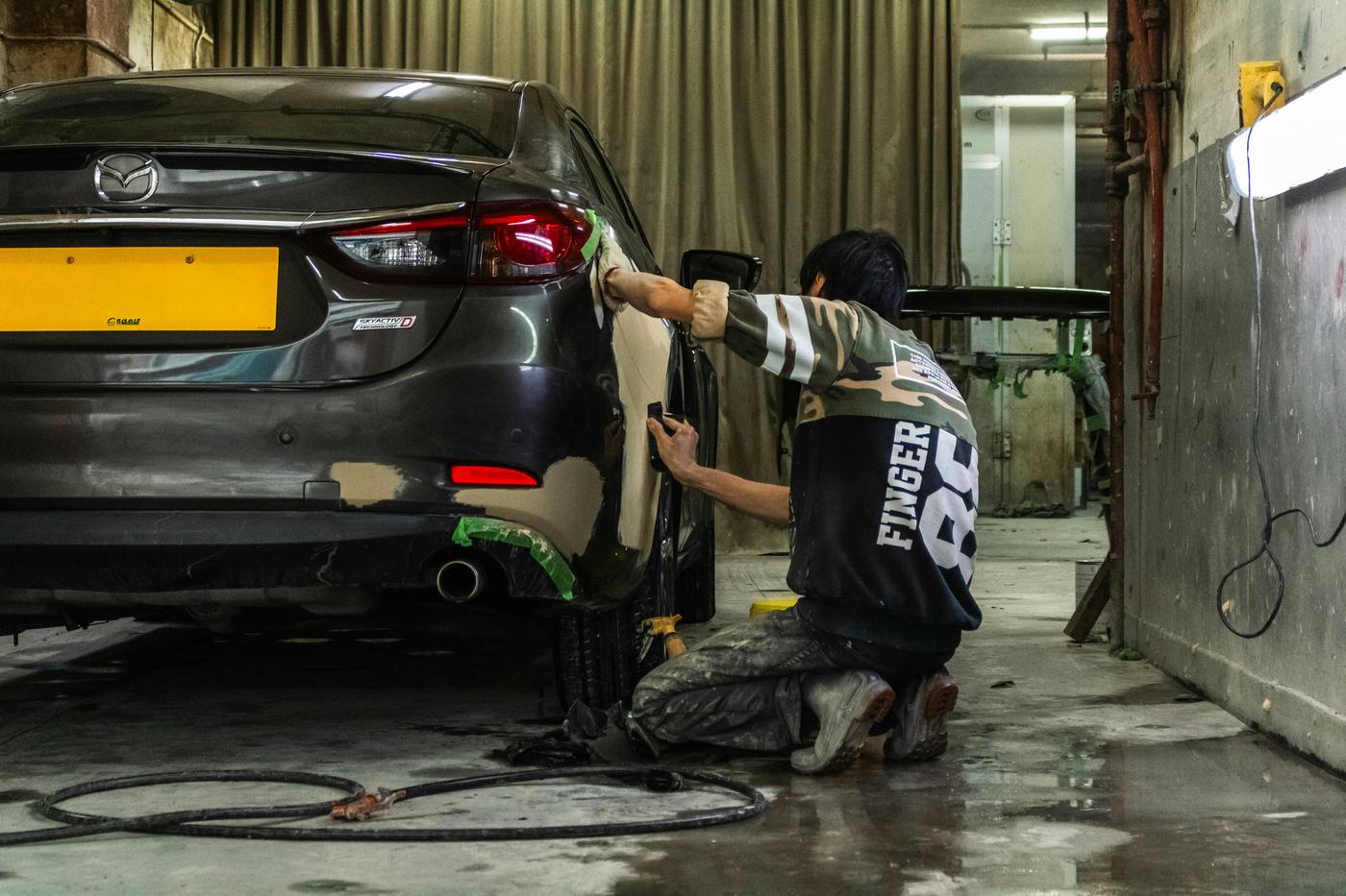 Cars on hoists inside a clean, well-lit accident repair workshop